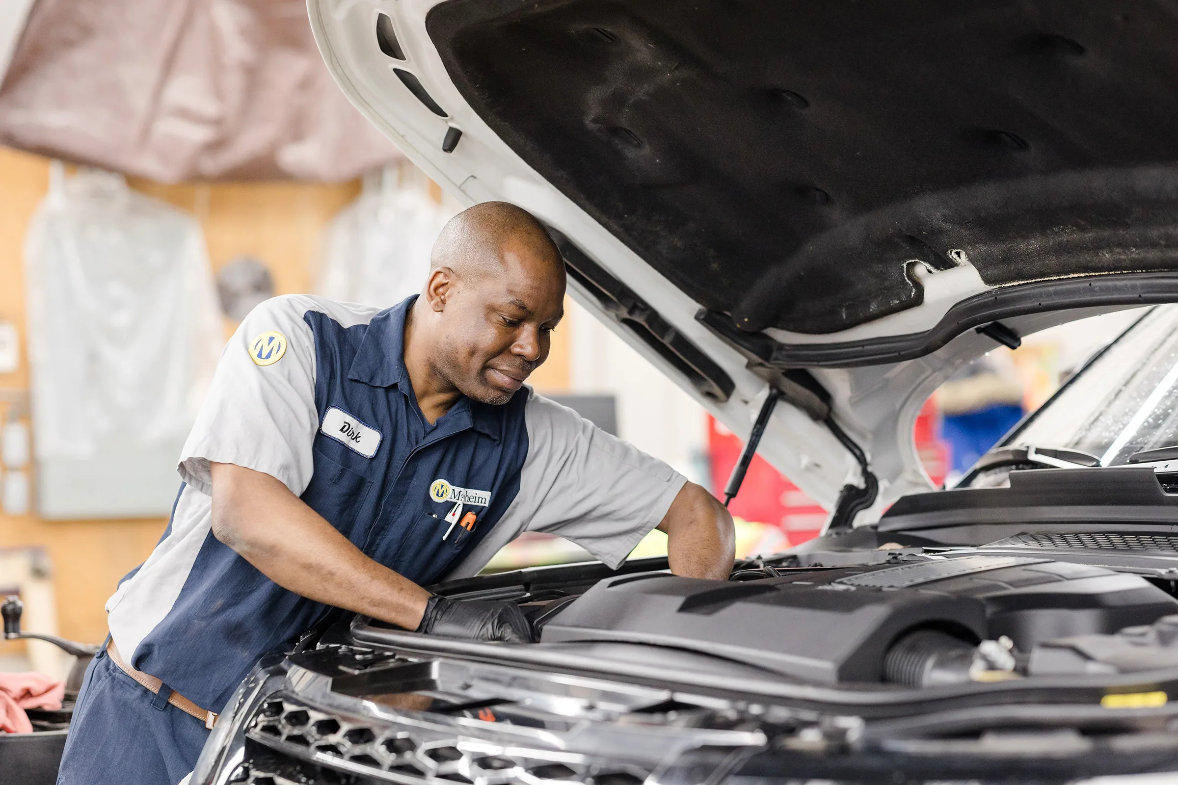 A mechanic inspecting the engine of a land rover.