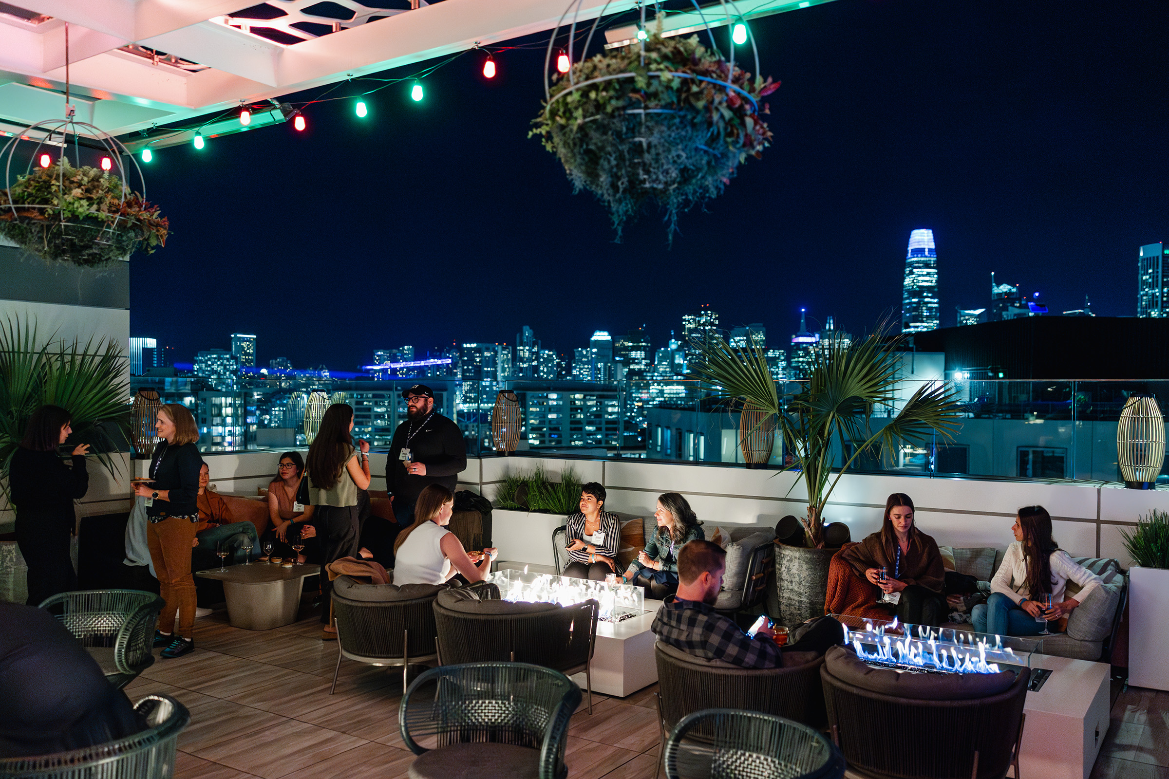 A group of people engaged in content creation on a rooftop with a view of the city.