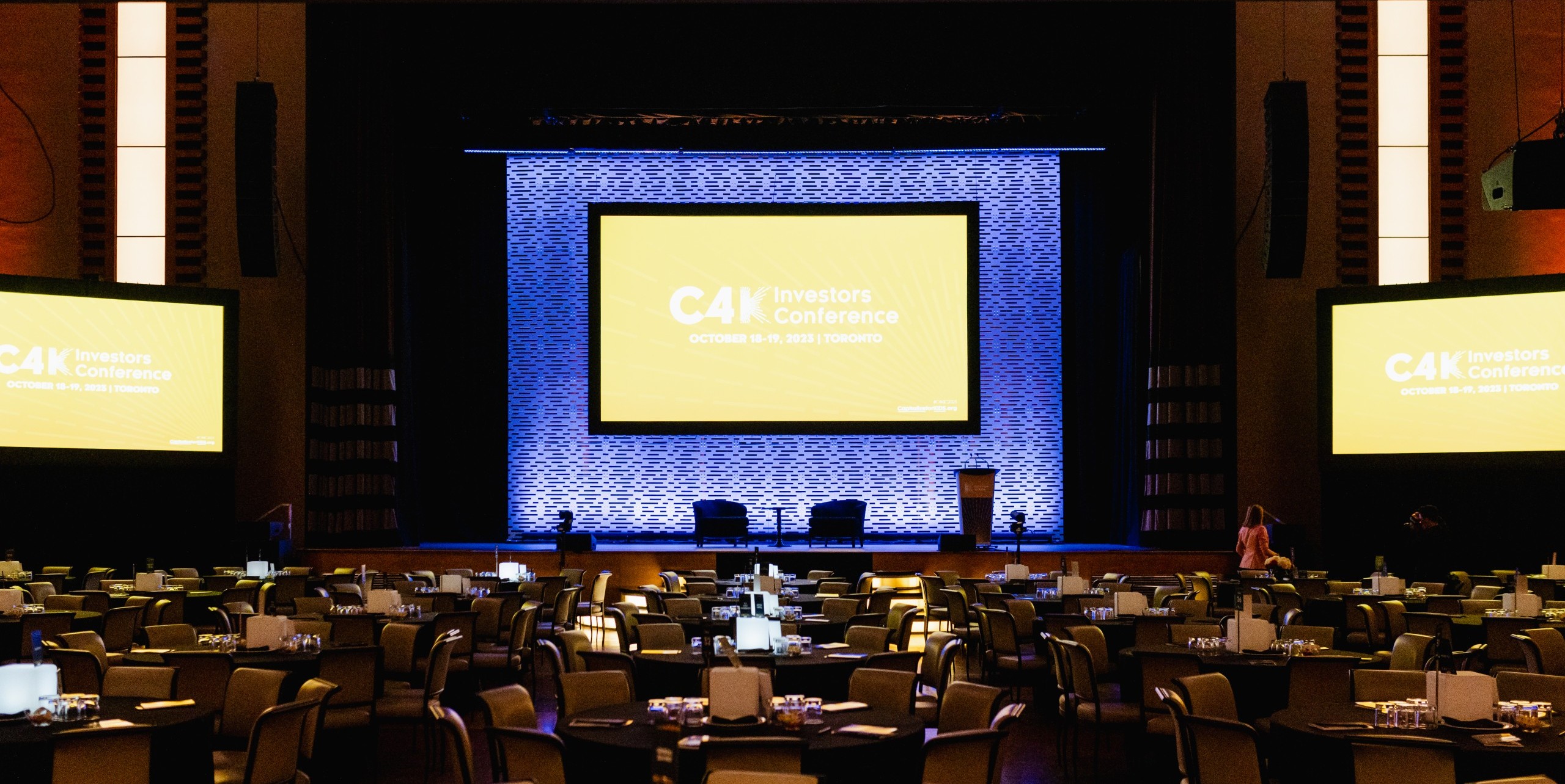 A large stage with tables and chairs, ideal for conference photography.