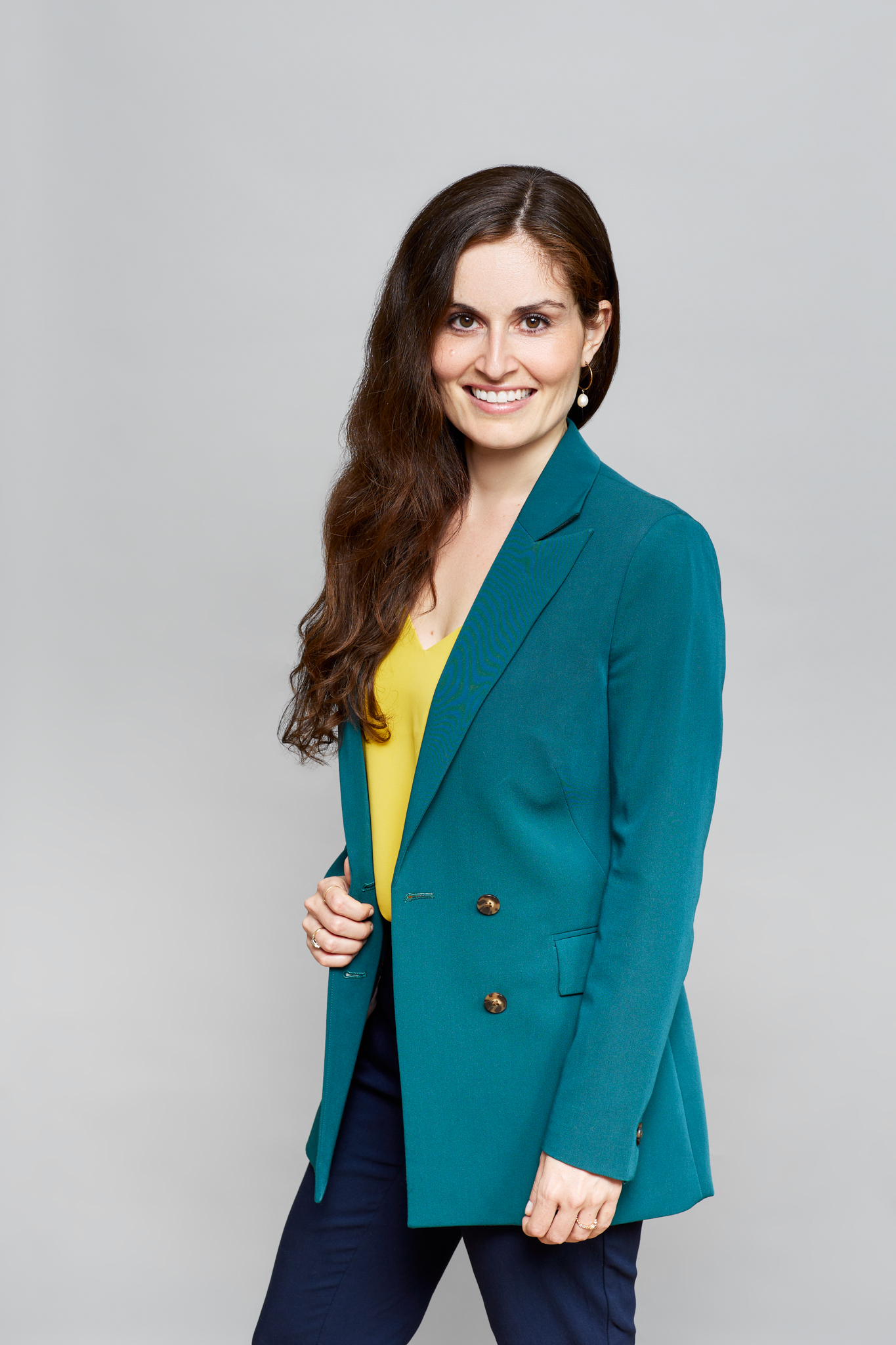 An event photographer captures a woman in a teal blazer in a posed photo.