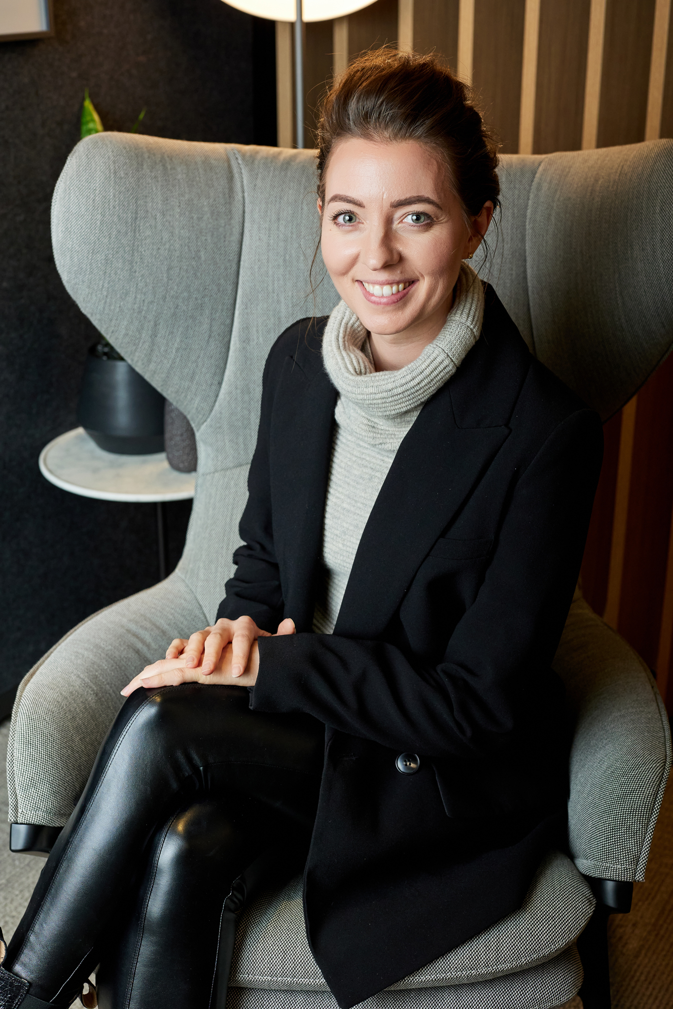 An elegantly dressed woman sitting on a chair, captured through event photography.
