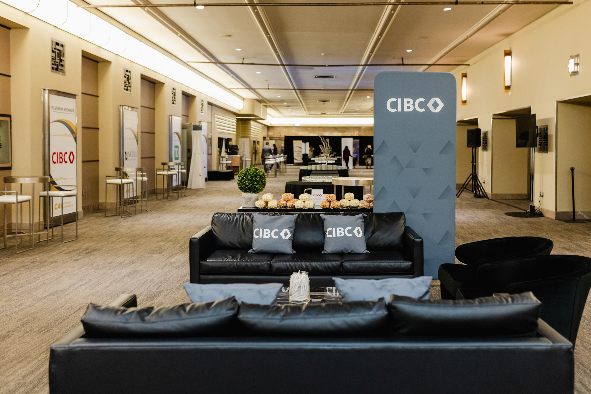 The conference room lobby features sleek black couches and modern tables, creating a sophisticated atmosphere perfect for conference photography.