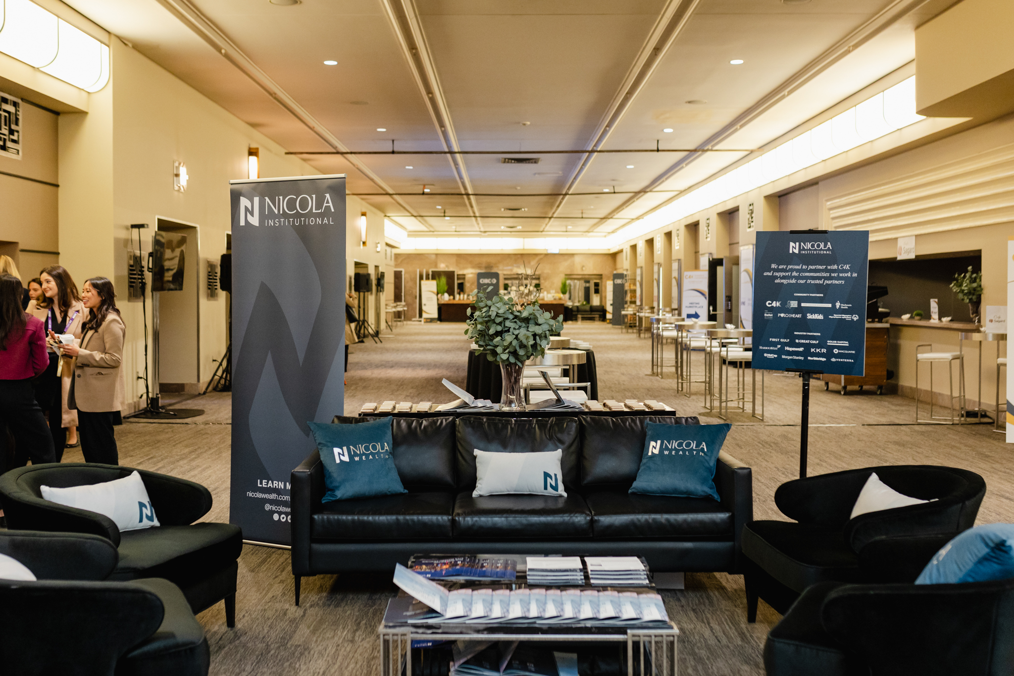 A lobby with conference-style seating arrangements, including comfortable couches and sleek tables.