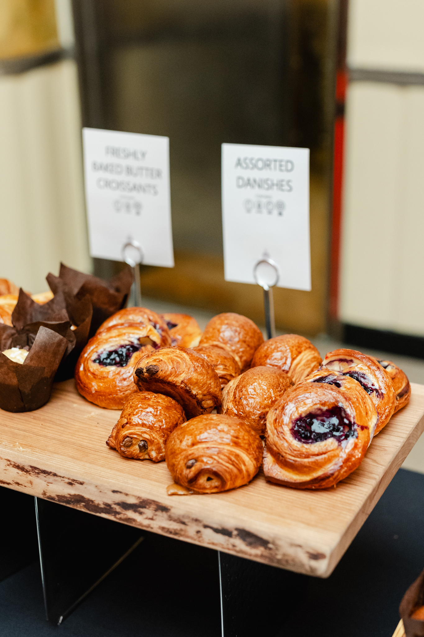 Conference Photography: A display of pastries on a wooden table is captured in this stunning photograph.