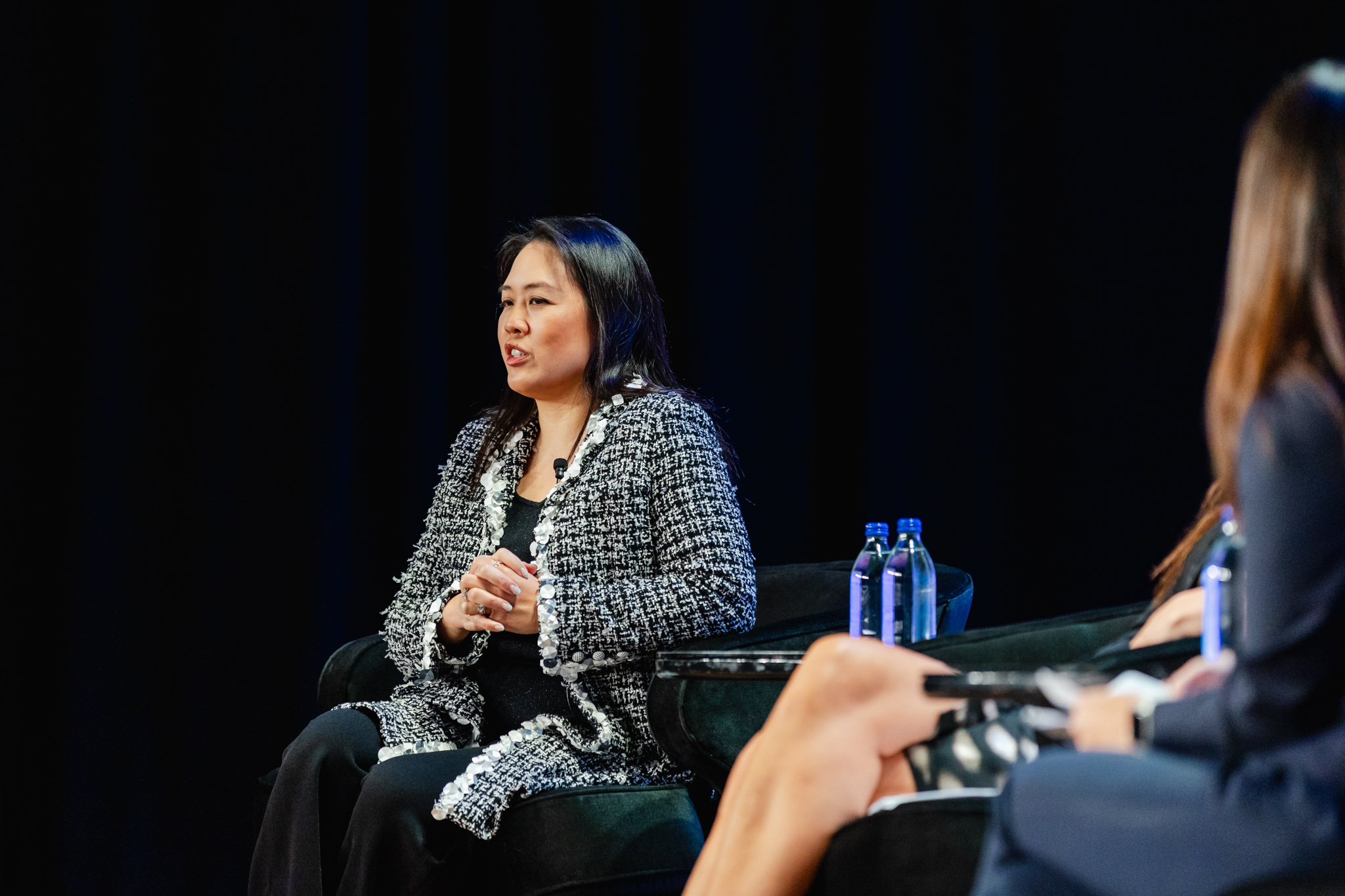 Two women engaged in a meaningful conversation on stage at a conference.
