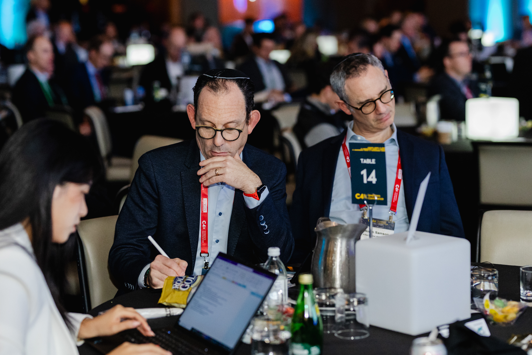 Conference Photography: A group of people sitting at a table with laptops, captured in a visually engaging manner.