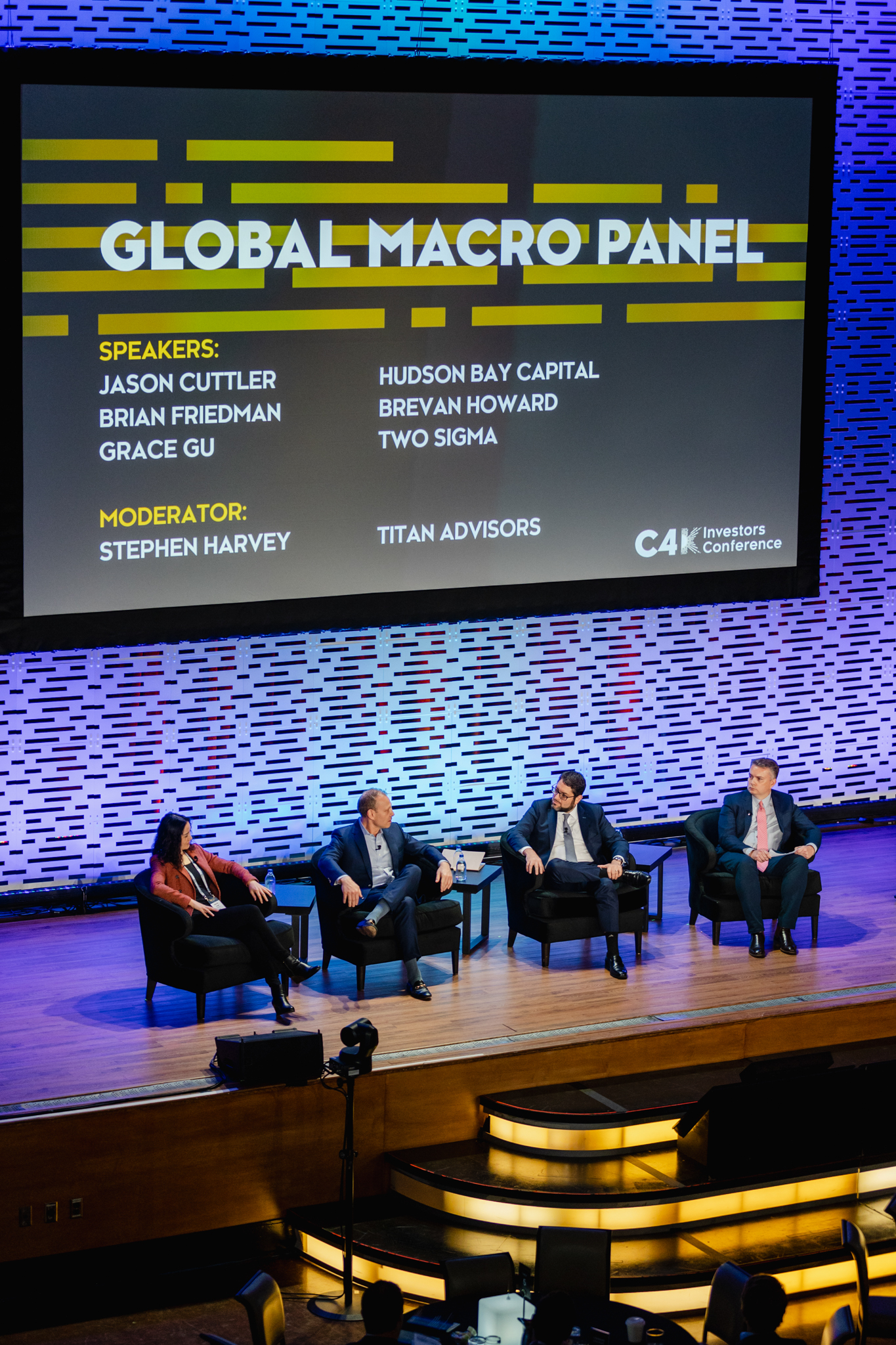 Conference speakers on stage at a global macro panel.