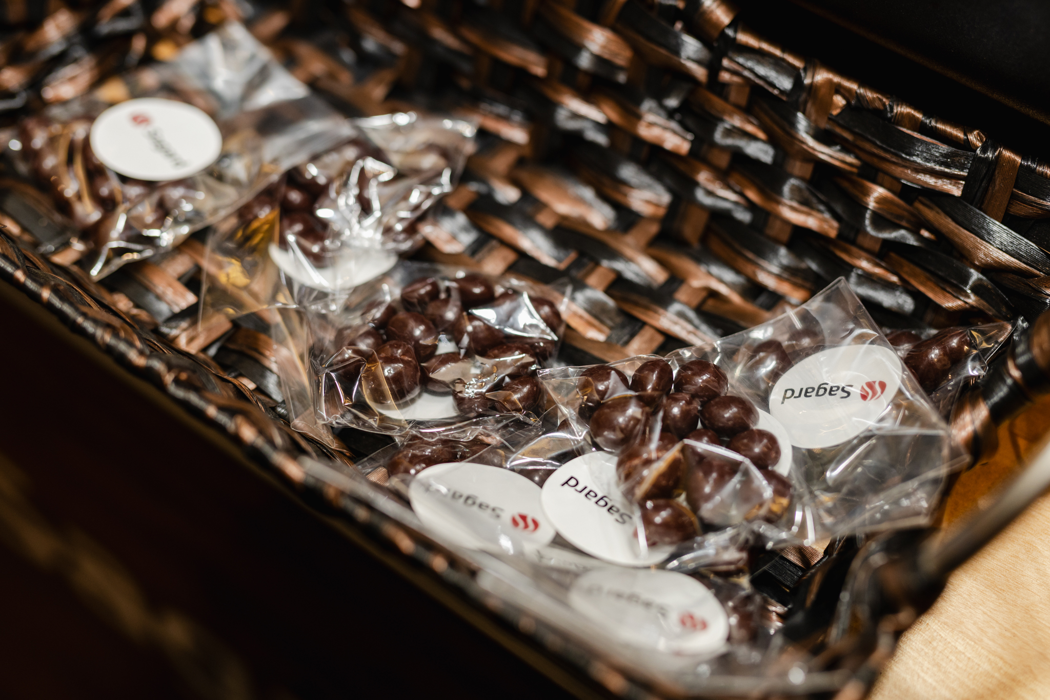 Conference attendees enjoying a delectable assortment of chocolates displayed in an elegant basket on a table.