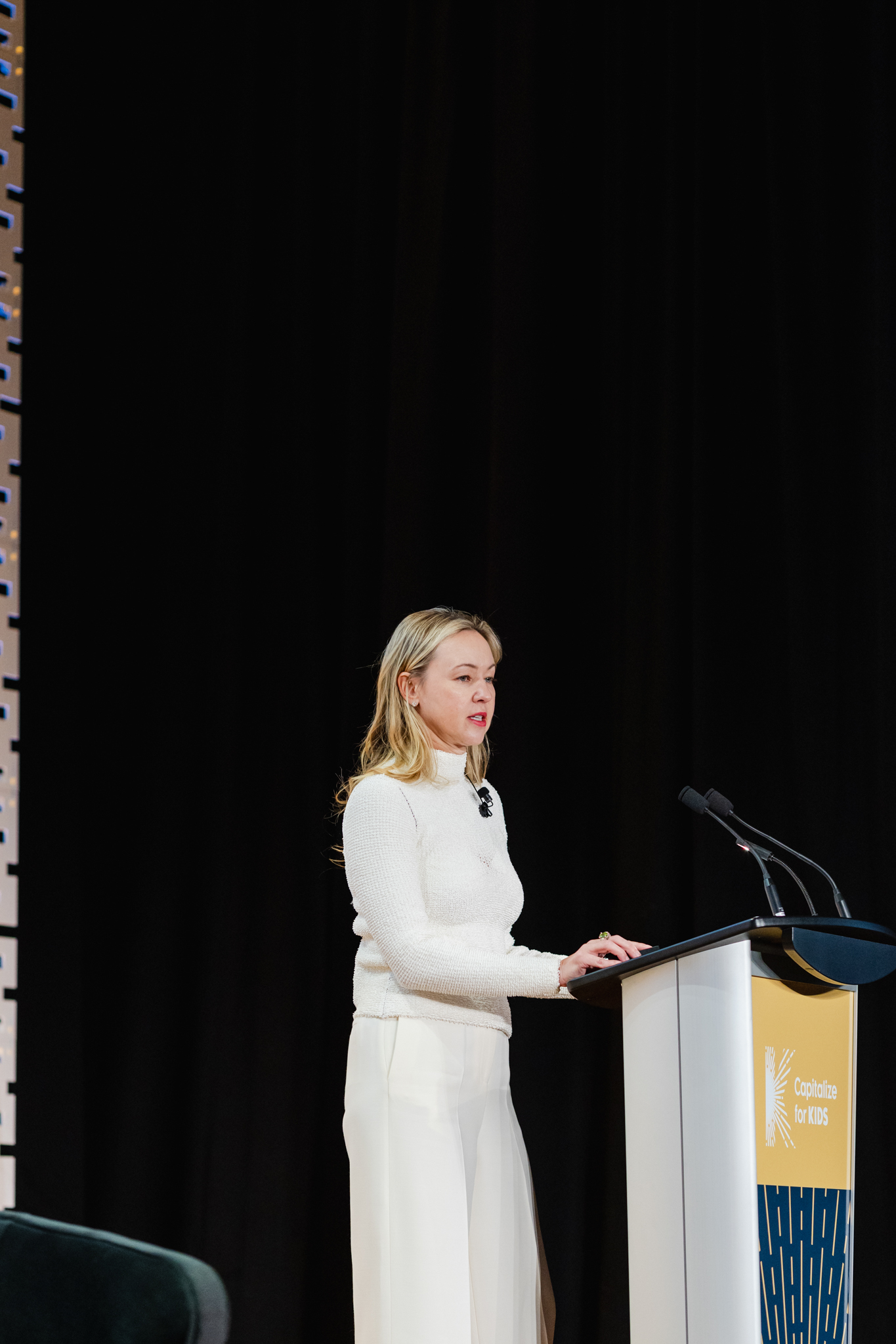 A woman delivering a speech at a conference, confidently standing at a podium.