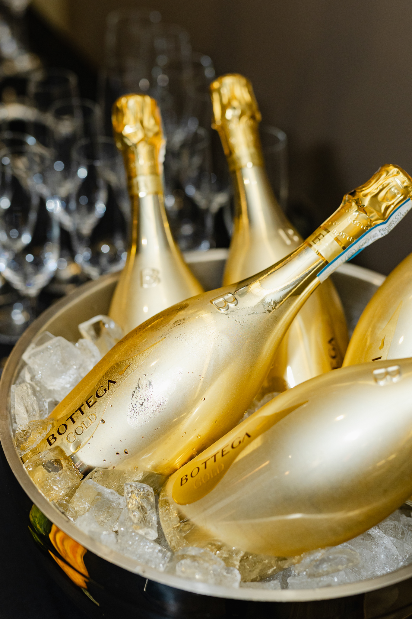 Conference Photography: Capturing the elegance of four gold bottles of champagne in a bowl of ice.