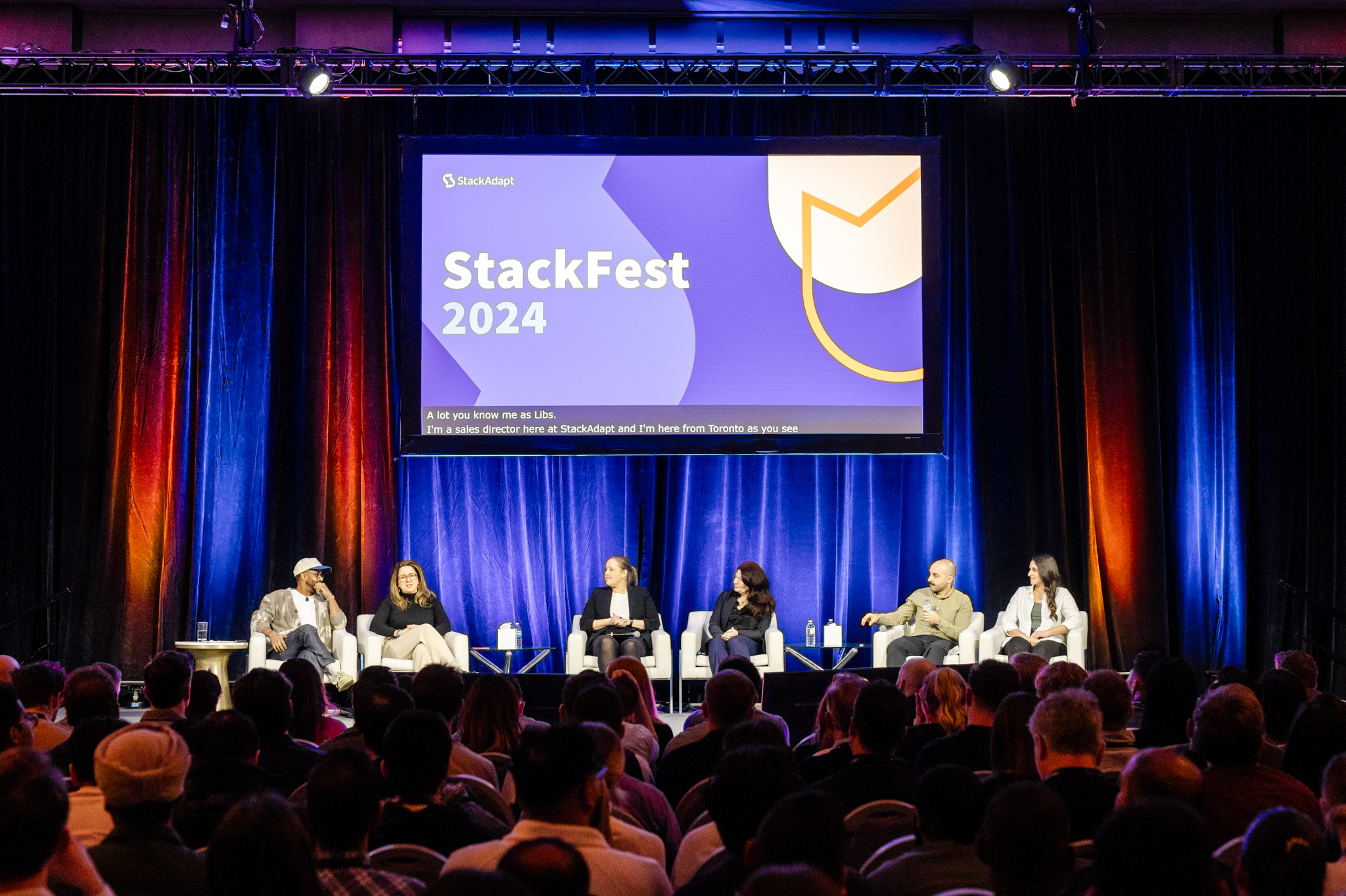 Event photography capturing a vibrant group of people on stage at stackfest.