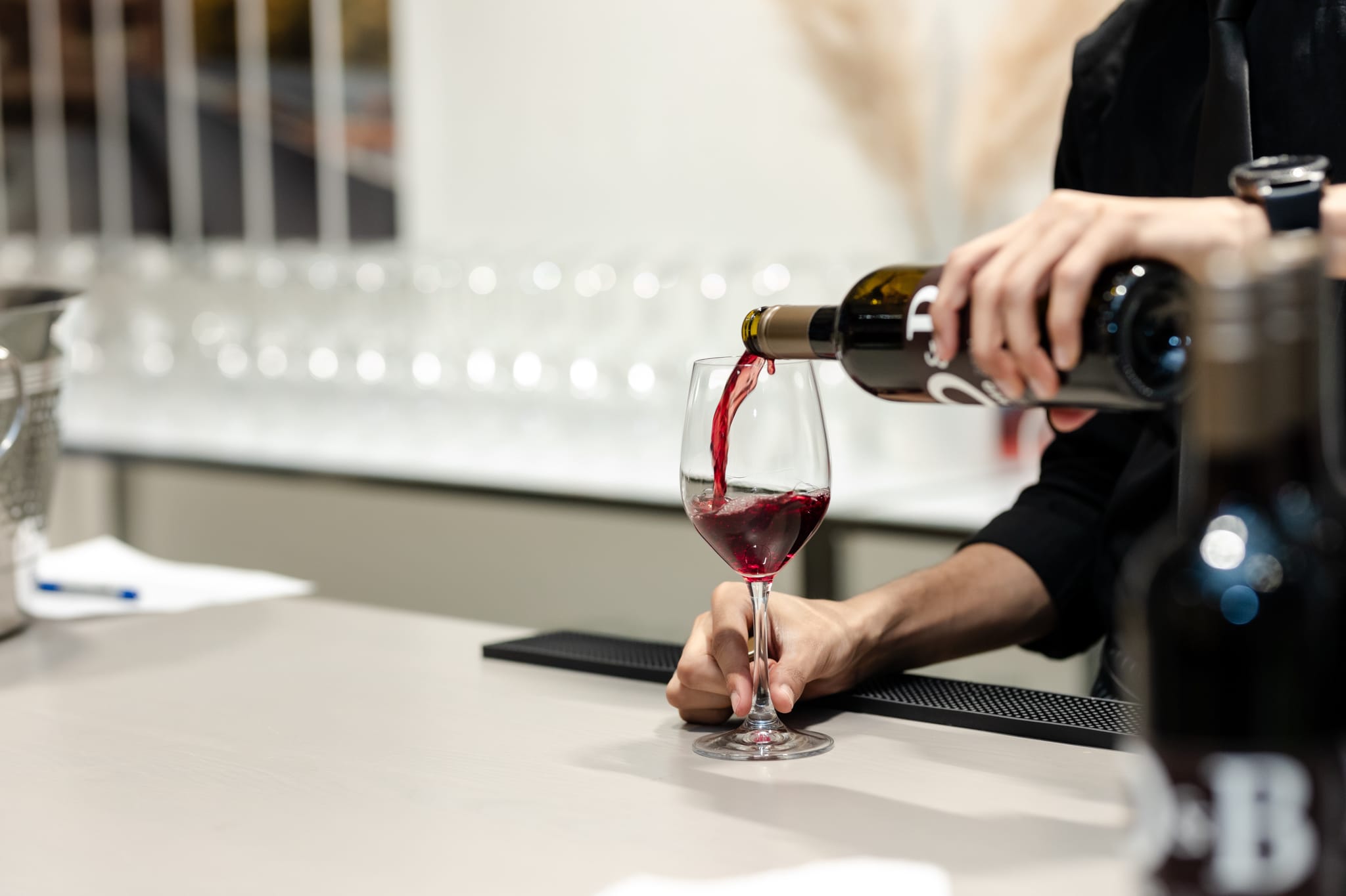 A person is pouring wine at an event.