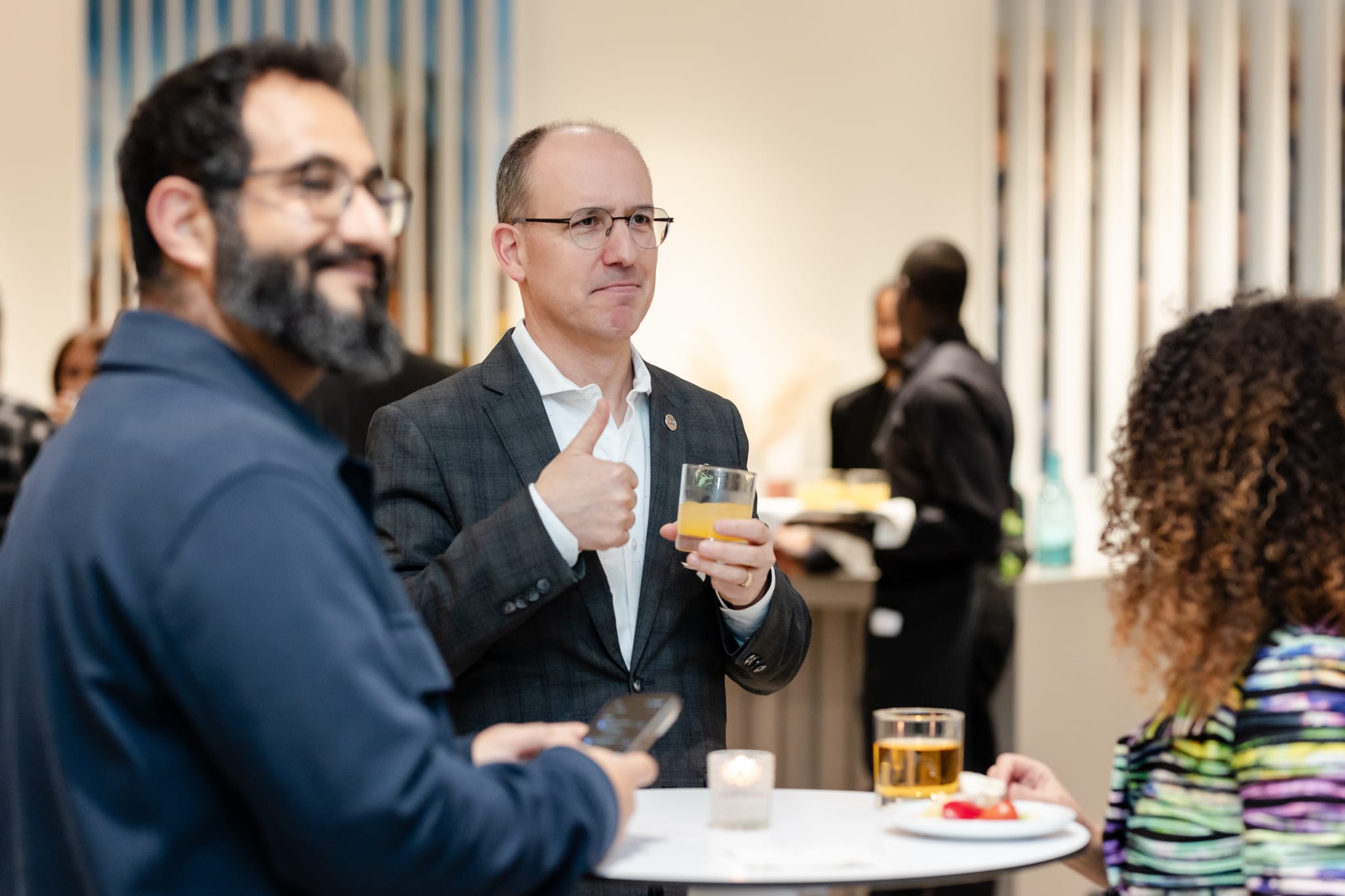 A group of people at an event, conversing with each other.