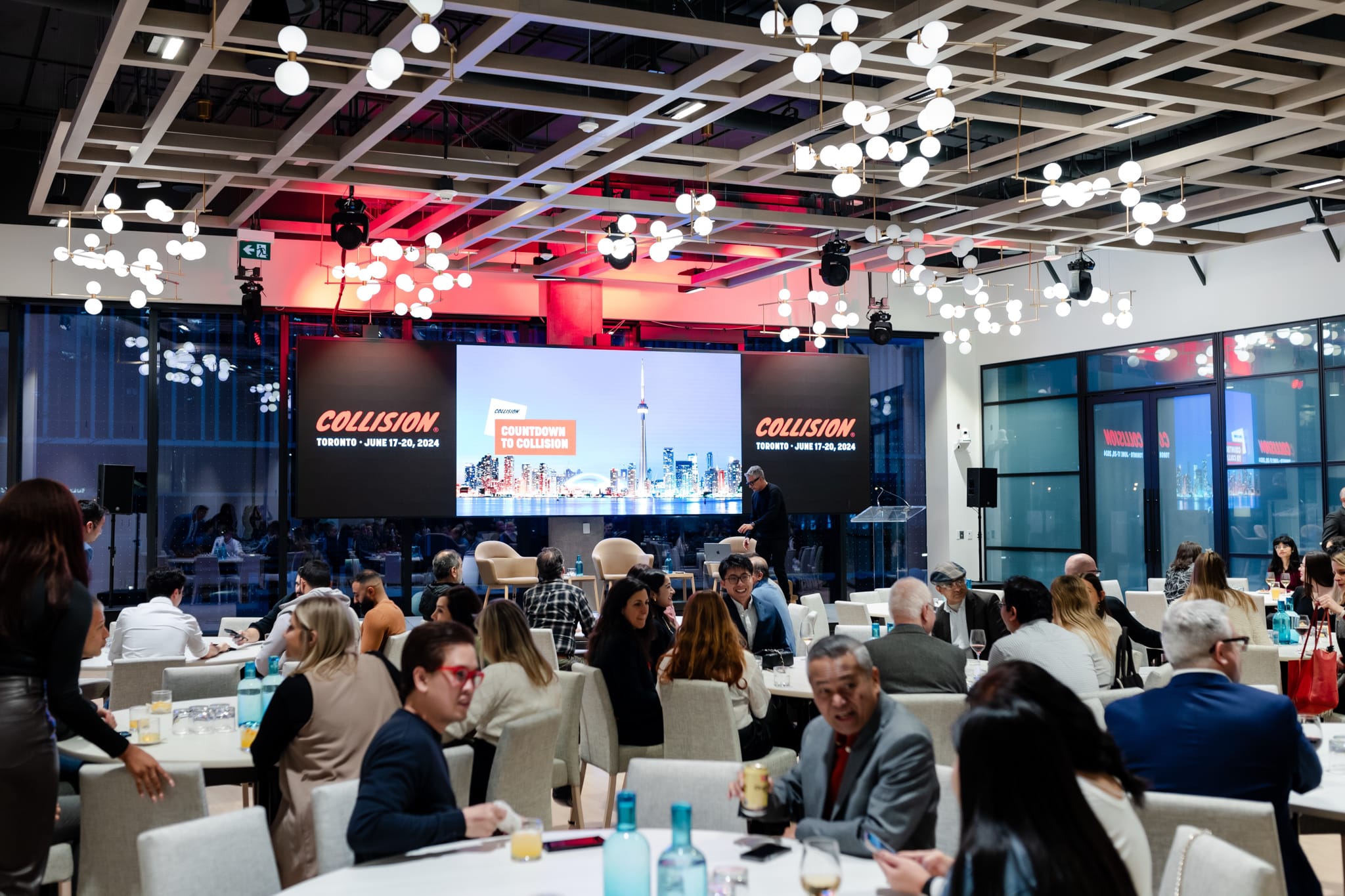 Event photography capturing people in a conference room sitting at tables.