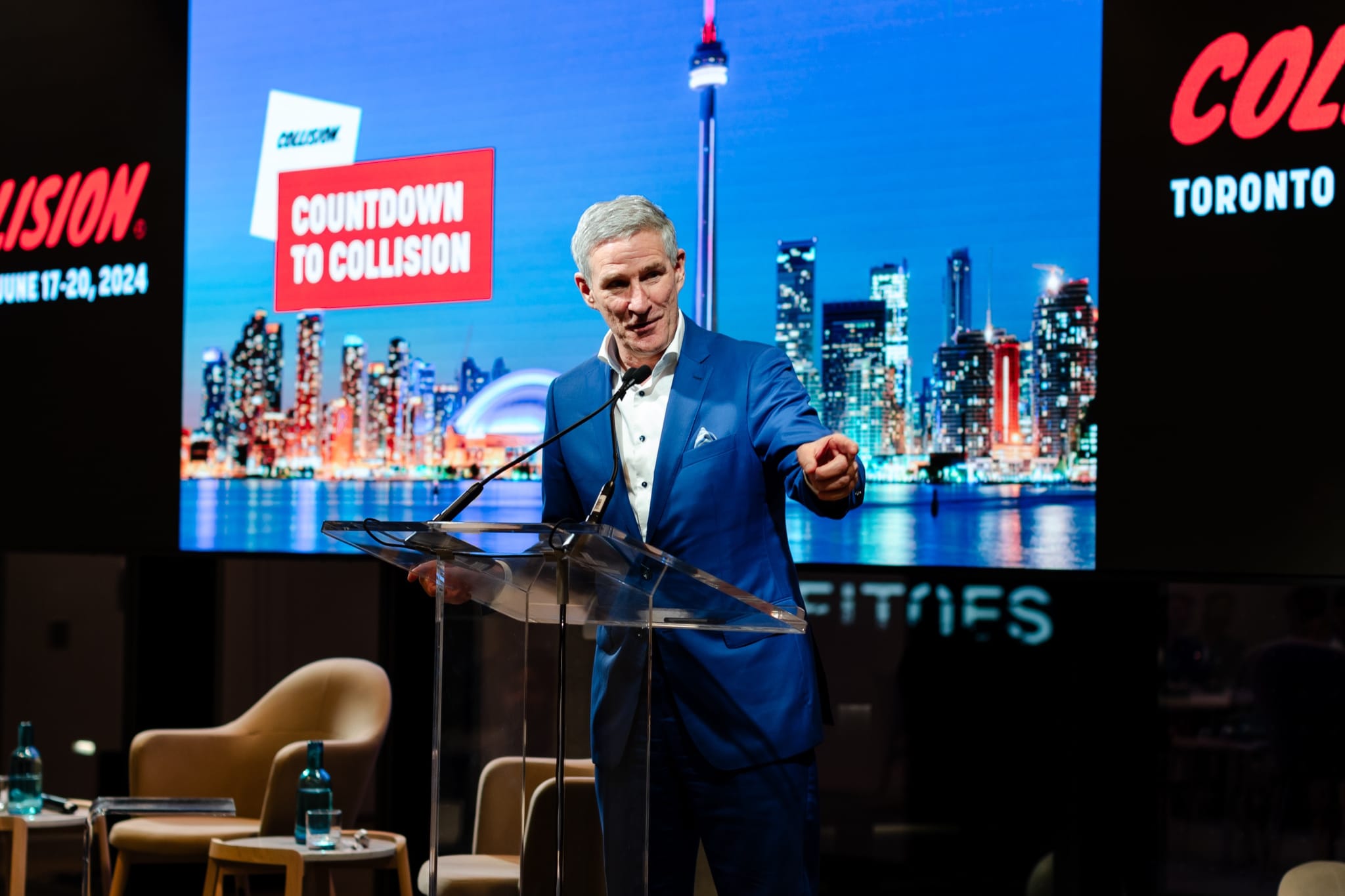 A man in a suit giving a speech at an event.