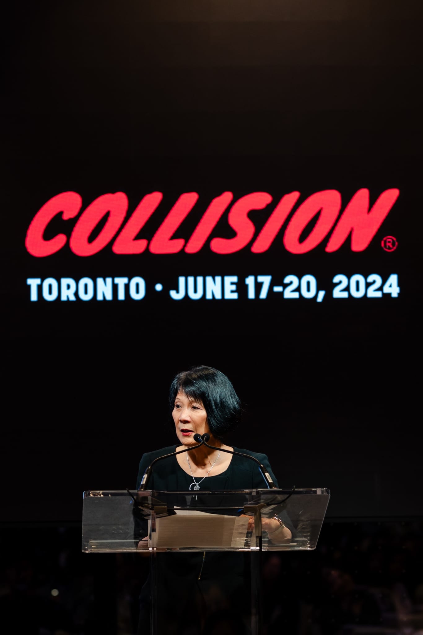 A woman speaks at a podium during the Collision Toronto event.