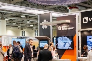 Attendees engaging with exhibitors at a trade show booth for Boart Longyear, captured in corporate photography.