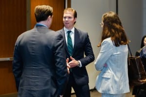 Three professionals engaging in a conversation at an event photography business event.