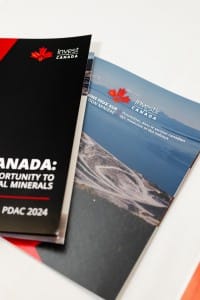 Brochures promoting investment in Canada's mining sector, including event photography, displayed at PDAC 2024.