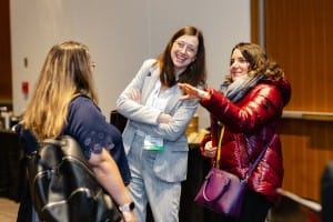 Three individuals engaging in a friendly conversation at an indoor event photography session.