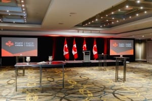 Preparation for a formal event, including event photography, with Canadian flags and Invest in Canada branding.