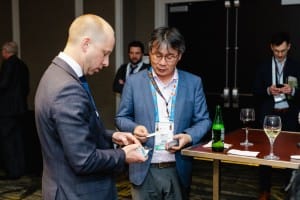 Two professionals exchanging information at an event photography conference.