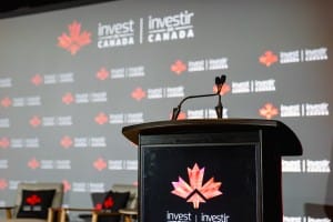 A podium with microphones in front of a screen, set up for event photography.