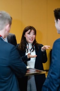 A professional woman engaging in a lively conversation with two individuals at an event photography session.