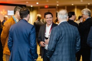 A group of professionals engaged in conversation at a networking event with event photography capturing the moments.