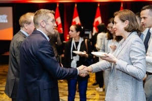 Two professionals shaking hands at a networking event photography session.