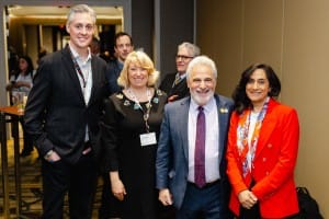 Four professionals posing for a photo at an event photography conference.