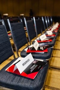 Rows of empty chairs with reserved signs in an event photography setting in a conference hall.
