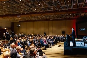 A speaker addressing an attentive audience at a conference event with event photography capturing the moment.