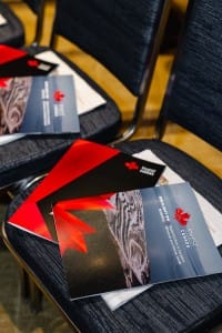 Conference brochures placed on chairs in a seminar room for an event photography seminar.