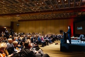 Speaker presents to an audience at a conference event with event photography capturing the moment.