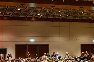 Audience members seated in a conference hall during a corporate event, with some individuals standing.
