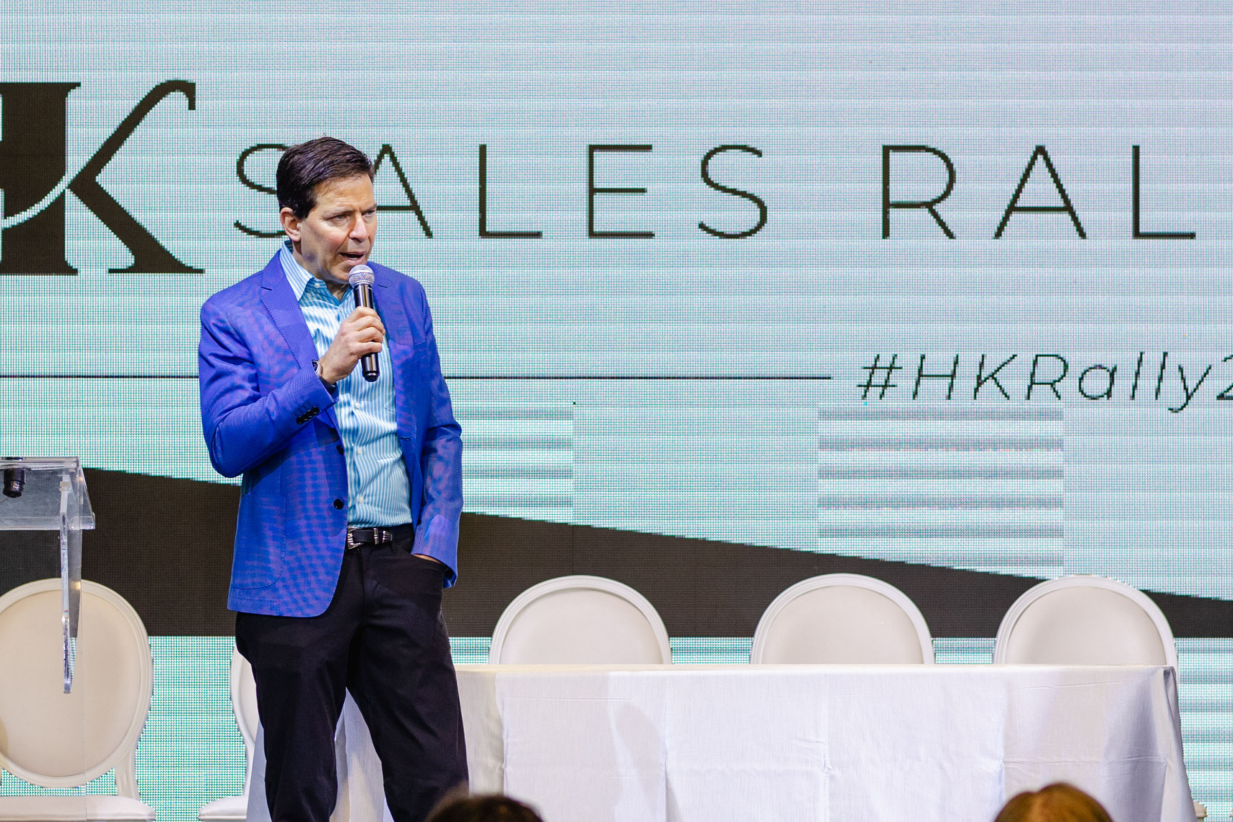 Man giving a speech at a corporate sales rally event.