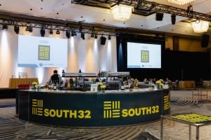 A bar in a conference room with a screen behind it, perfect for event photography.