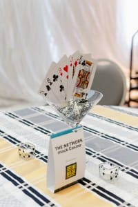 Event photography capturing playing cards in a martini glass on a table.