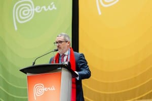 A man in a suit standing at a podium during an event photography session.