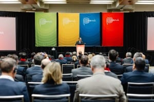 A man is giving a speech at an event photography conference.