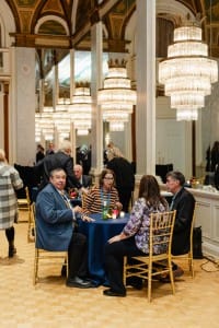 A group of people sitting at a table during an event.