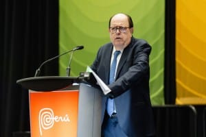 A man in a suit standing at a podium during an event photography session.