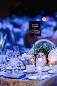 A table with a sign on it, ready for event photography.