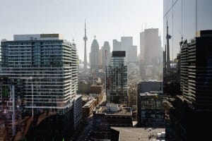 A cityscape view featuring a mix of high-rise buildings and skyscrapers with a prominent tower in the background under a clear sky, captured with the precision typical of corporate photography.