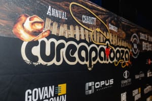 Banner for "Cureapalooza" annual charity concert with cowboy hat graphic, featuring event and sponsor logos—including Govan Brown, Opus Mechanical, and Symmetrix Solutions—and capturing the excitement through dynamic social event photography.