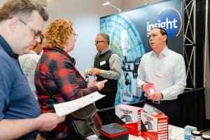 People interacting at a trade show booth displaying Arunalight products, captured through event photography that highlights the vibrant energy and genuine connections formed during this engaging showcase.