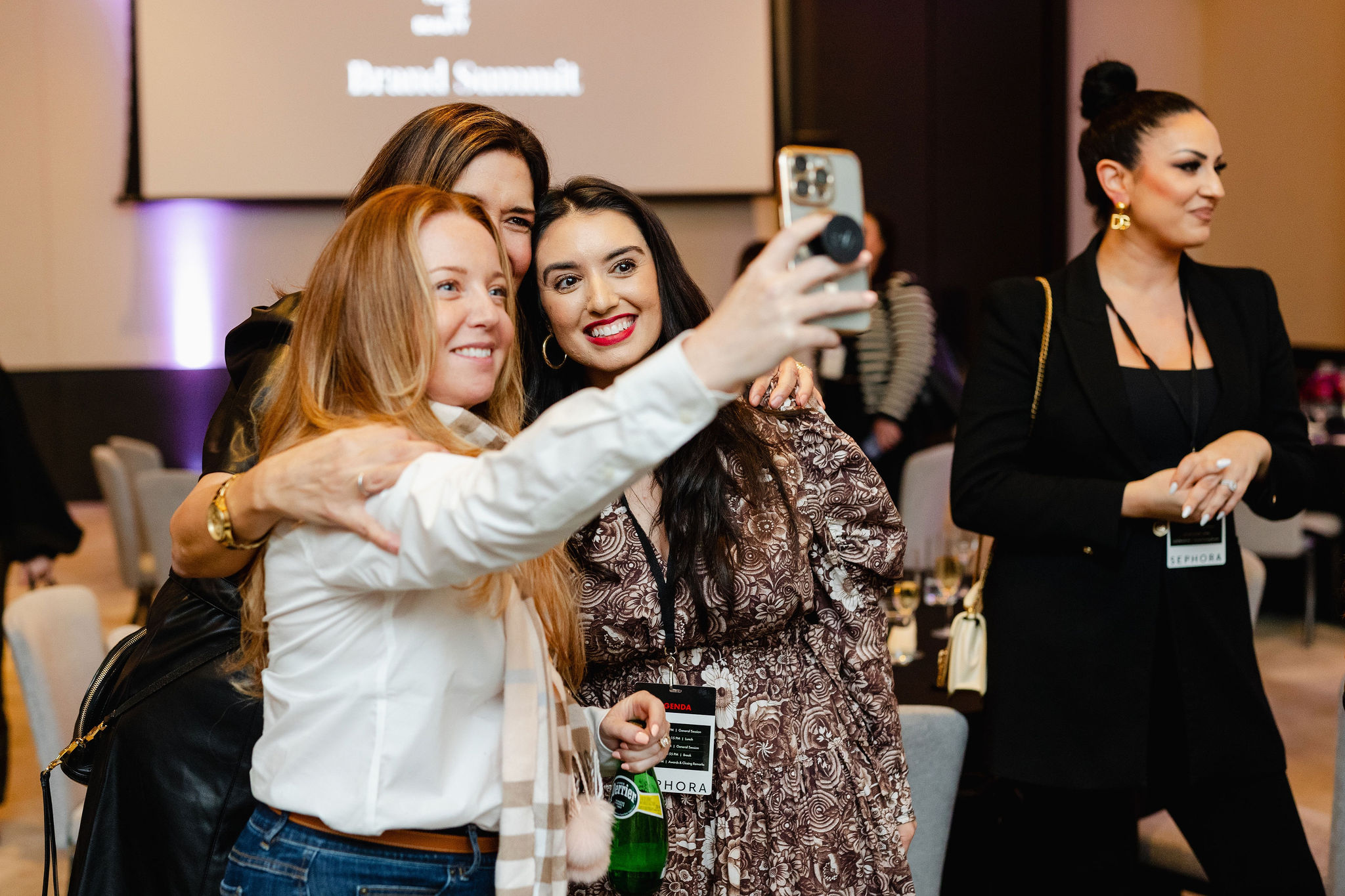A group of women capture the moment with a selfie at an indoor event, perfectly embodying the essence of brand photography.