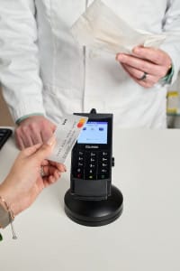 A person skillfully captures the moment as someone holds a credit card near a payment terminal for contactless payment, while another stands in the background with a receipt, perfectly illustrating event photography's ability to tell compelling stories through images.